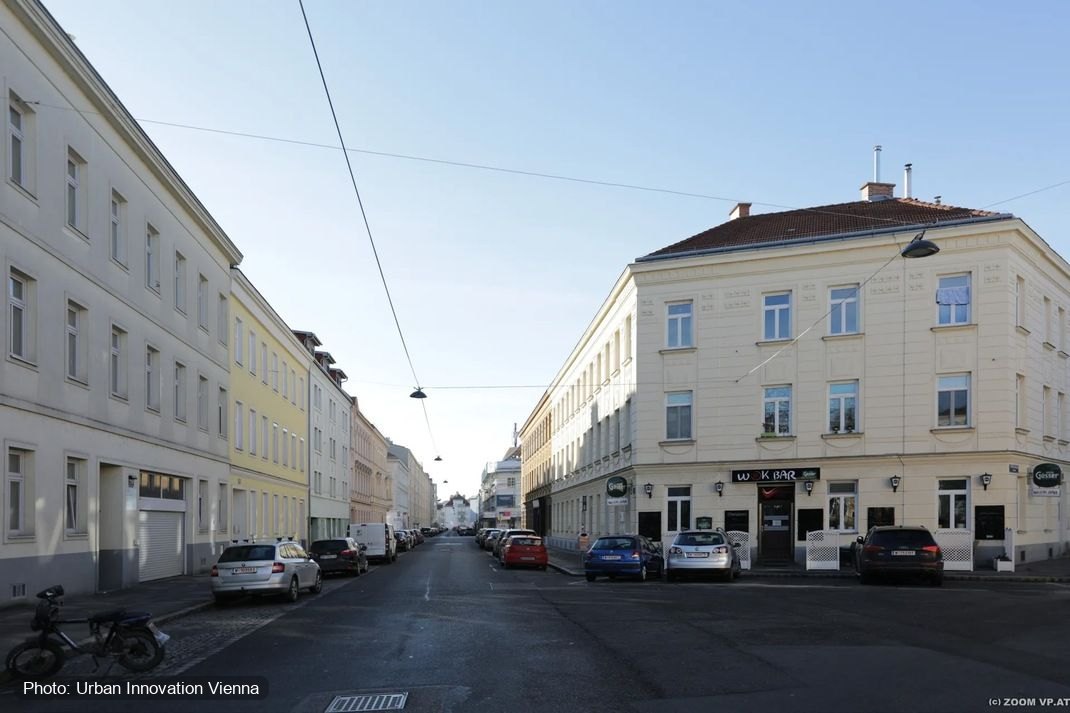 A street corner in Vienna as it is: asphalt, parked cars and a corner café.