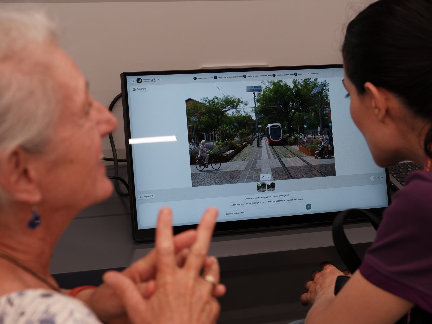 An older woman and a younger woman reading a street image together on the touchscreen.